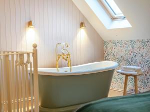 een badkamer met een bad op zolder bij 1 Bed in Alton oc-95760 in West Worldham +15 foto's