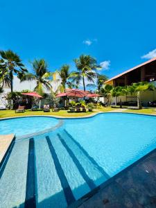 una piscina en un complejo turístico con palmeras en Pousada Sunrise Beach Cumbuco, en Cumbuco