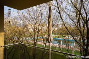 an umbrella on a balcony with a view of a pool at Studio Fortuna Park Residence in Sfântu-Gheorghe