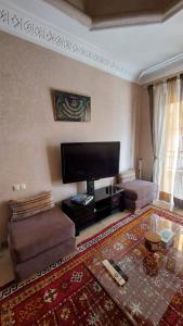 a living room with a large flat screen tv at Appartement Ksour in Sraghna