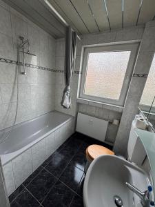 Ferienwohnung Monteurwohnung Business Appartement Langenfeld في Gladbach: حمام مع حوض استحمام ومرحاض ومغسلة