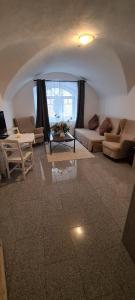 Una sala de estar con dos sofás y una mesa. en ALTSTADT-Apartmenthaus BOGENSPERGER, en Braunau am Inn