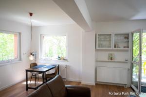a living room with a table and chairs in a room at Studio Fortuna Park Residence in Sfântu-Gheorghe