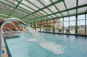 una piscina con una fuente de agua en un edificio en Résidence Pierre & Vacances Premium Presqu'Ile de la Touques, en Deauville