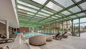 una piscina con tumbonas y una piscina en Résidence Pierre & Vacances Premium Presqu'Ile de la Touques, en Deauville