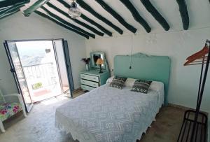 a bedroom with a bed and a large window at Casa Lola in Benaocaz