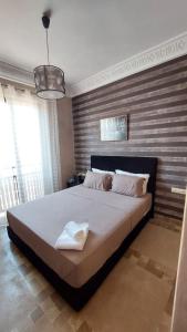 a bedroom with a large bed with a wooden wall at Appartement Ksour in Sraghna +11 photos