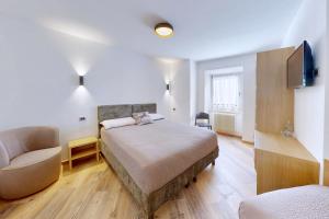 La Canonica di Termenago في بيليزانو: غرفة نوم بها سرير وكرسي وتلفزيون