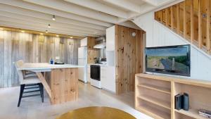 a kitchen with wooden walls and a large screen tv at Tide & Timber by Bayley Vacation Rentals in Old Orchard Beach