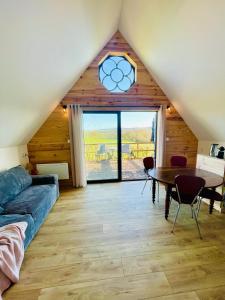 Una sala de estar con una mesa y una gran ventana. en Domaine Le Rianon, en Malleret-Boussac