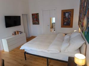 a living room with a white bed and a television at Studio Berlin Center in Berlin