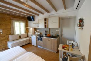 een kleine keuken met een bank en een tafel in een kamer bij Vasilis Boutique Studios in Myrties