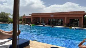 a large swimming pool in front of a building at Appartement Ksour in Sraghna