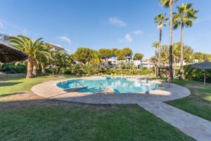 una piscina in un parco con palme di Miraflores Luxury Duplex a Mijas Costa