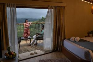 Uma mulher em pé numa varanda com um homem sentado numa cadeira. em Monticle Glamps em Vagamon mais 31 fotografias
