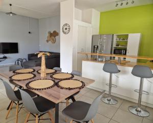 a kitchen and dining room with a table and chairs at Maïlly - Charmante villa T5 avec piscine - Empire House in Capesterre-Belle-Eau