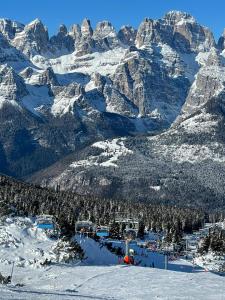 Appartamenti al Parco في مولفينو: جبل مغطى بالثلوج مع وجود منتجع التزلج في المقدمة