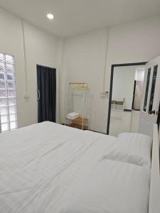 Haru Home Khaoyai في Nong Nam Daeng: سرير أبيض في غرفة بيضاء مع مرآة