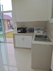 Haru Home Khaoyai في Nong Nam Daeng: مطبخ أبيض مع حوض وميكروويف