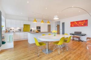 a kitchen and dining room with a table and yellow chairs at 4 Bed in Killay oc-c28372 in Killay
