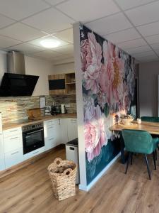 eine Küche mit einem Tisch und einer Wand mit Blumen in der Unterkunft Lagerhaus Gabriel-Oasen in der Stadt in Zweibrücken