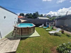 Maïlly - Charmante villa T5 avec piscine - Empire House في كابستر-بيل-أو: حديقة خلفية مع حوض استحمام ساخن وسطح مع كراسي
