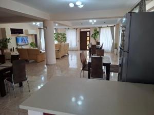 ein Zimmer mit Tischen und Stühlen und ein Wohnzimmer in der Unterkunft B&B Granada in Covasna