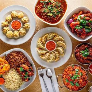 une table pleine d'assiettes de nourriture avec des aliments différents dans l'établissement Green Hill Home, à Darjeeling