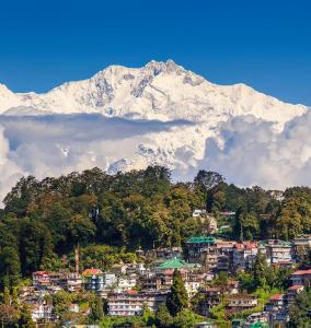 une montagne enneigée devant une ville dans l'établissement Green Hill Home, à Darjeeling