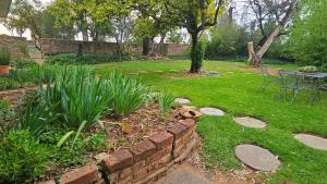 a garden with a brick wall and a table in a yard at Home with The Hoffs in Smithfield +7 photos