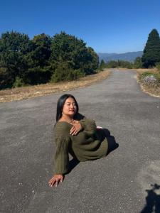 une femme allongée au milieu d'une route dans l'établissement Green Hill Home, à Darjeeling
