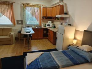 a small kitchen with a bed in a room at Kettő Ciprus Apartman in Hajdúszoboszló
