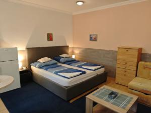 a small bedroom with a bed and a table at Kettő Ciprus Apartman in Hajdúszoboszló