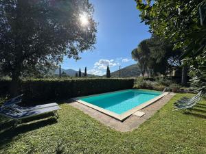 a swimming pool in a yard with two chairs at Allo Scoiattolo in Lucca