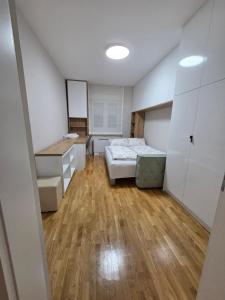 PARADISO STAN Bijeljina في بيه لينا: غرفة صغيرة بها سرير ومكتب