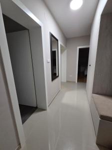 PARADISO STAN Bijeljina في بيه لينا: ممر فارغ بجدران بيضاء ومرآة