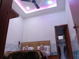 Un dormitorio con ventilador de techo y una cama. en Shree Girraj Dham Vrindavan, en Chhatikara