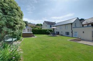 a large yard with a house and a lawn at 3 Bed in Croyde oc-beren in Croyde