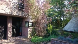 a house with a tree next to a building at Villa West heaven Valley Gent in Ghent