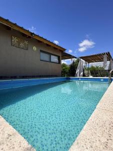 una piscina con acqua blu davanti a una casa di Los Frutales a Villa Carlos Paz