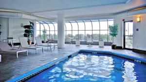 een groot zwembad in een grote ruimte met tafels en stoelen bij Oceanview Oasis Seaside Holiday Retreat in Old Orchard Beach