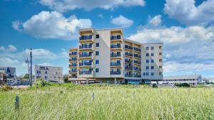 een hoog appartementengebouw in een veld met hoog gras bij Oceanview Oasis Seaside Holiday Retreat in Old Orchard Beach