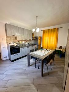 Casa Mirko في سان فيتو: مطبخ مع طاولة وكراسي في الغرفة
