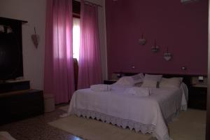 Casa Mirko في سان فيتو: غرفة نوم بسرير أبيض مع ستائر وردية +3 صور