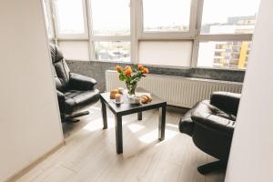 a living room with a table with flowers on it at Cosmic апартаменти з ванною in Ternopil