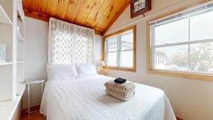 a bedroom with a white bed and a window at Sand Life #2 by Bayley Vacation Rentals in Old Orchard Beach