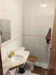 a bathroom with a sink and a toilet at Villa Enseada - Charme e conforto a 650m da Praia da Enseada in Guarujá +18 photos