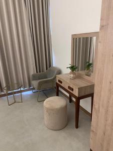 una sala de estar con una mesa y una silla en Inter Town Hotel, en Salalah