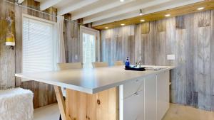 a kitchen with a large white counter and wooden walls at Tide & Timber by Bayley Vacation Rentals in Old Orchard Beach