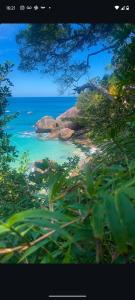Una vista de una playa con rocas y el océano. en Flat Trindade, en Trindade